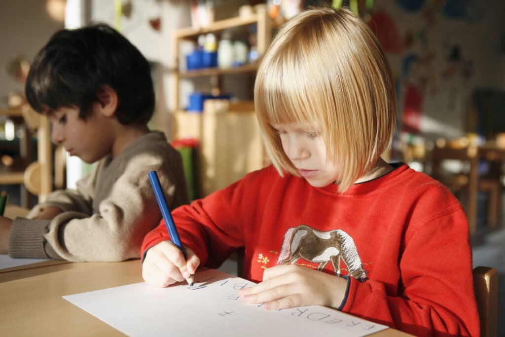 Mädchen lernt schreiben im Kindergarten